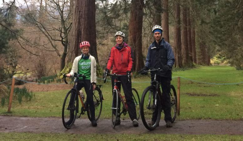 3 people on bikes in woodland.