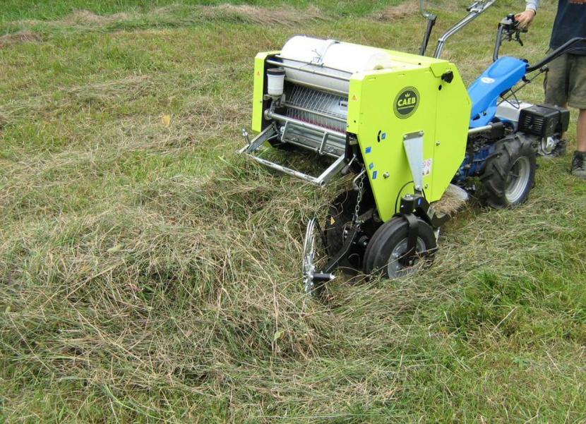 Mini baler lifting arisings after meadow cut