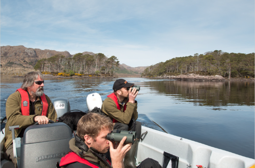 three people with binoculars in a small boat