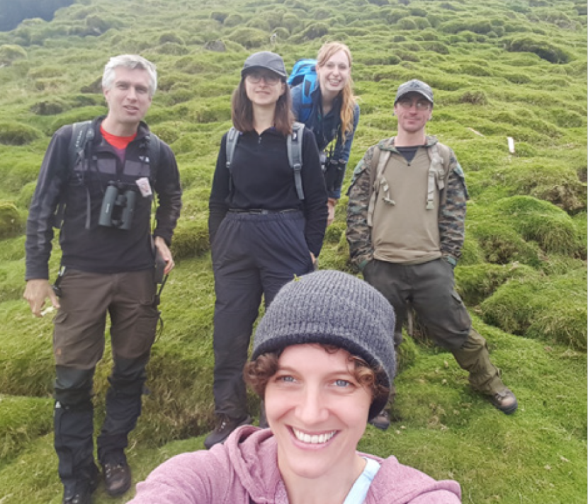 group of five people volunteering outdoors