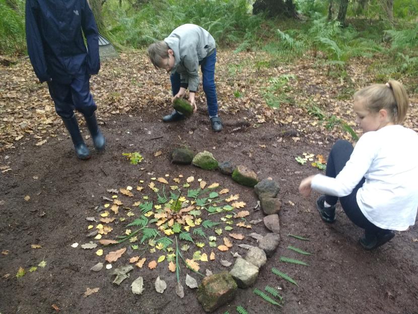 Three primary pupils in a woodland glade