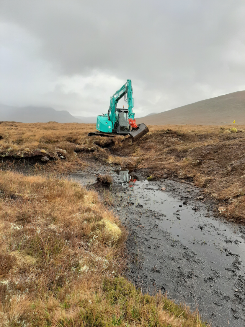 Machine operator reprofiling a gully edge.