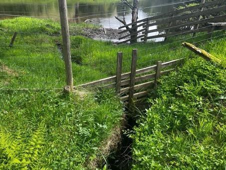 Wooden barrier on a small watercourse