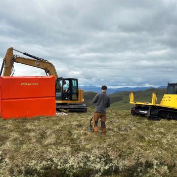 Restoration machinery and worker on peatland with hills in the background