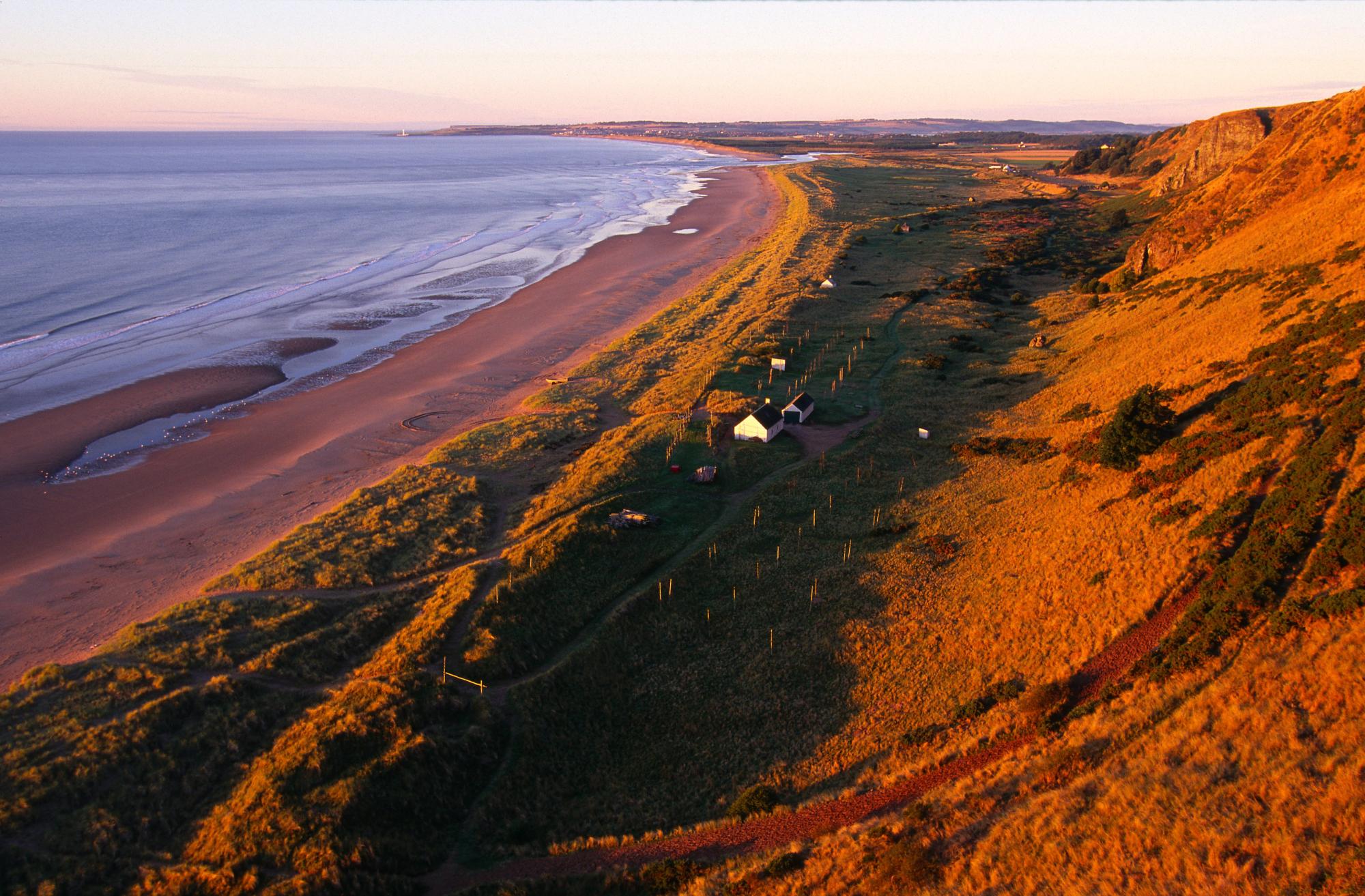 Dune ridges and old sea cliffs, going down to the beach and sea.