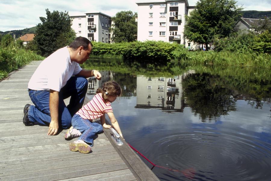 Family sitting beside the pond