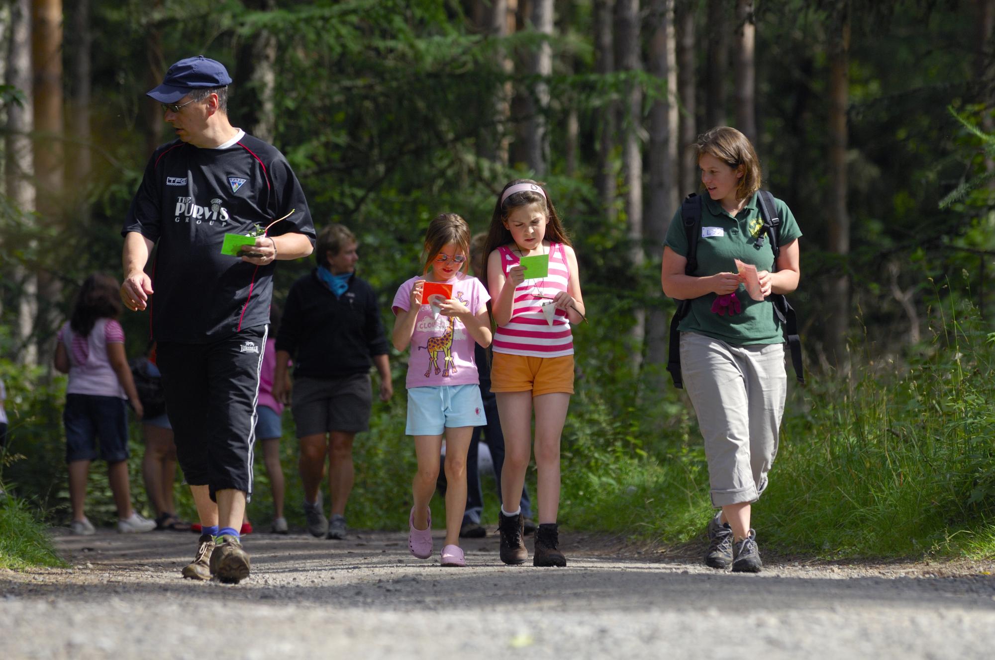 A park ranger walking with 2 children