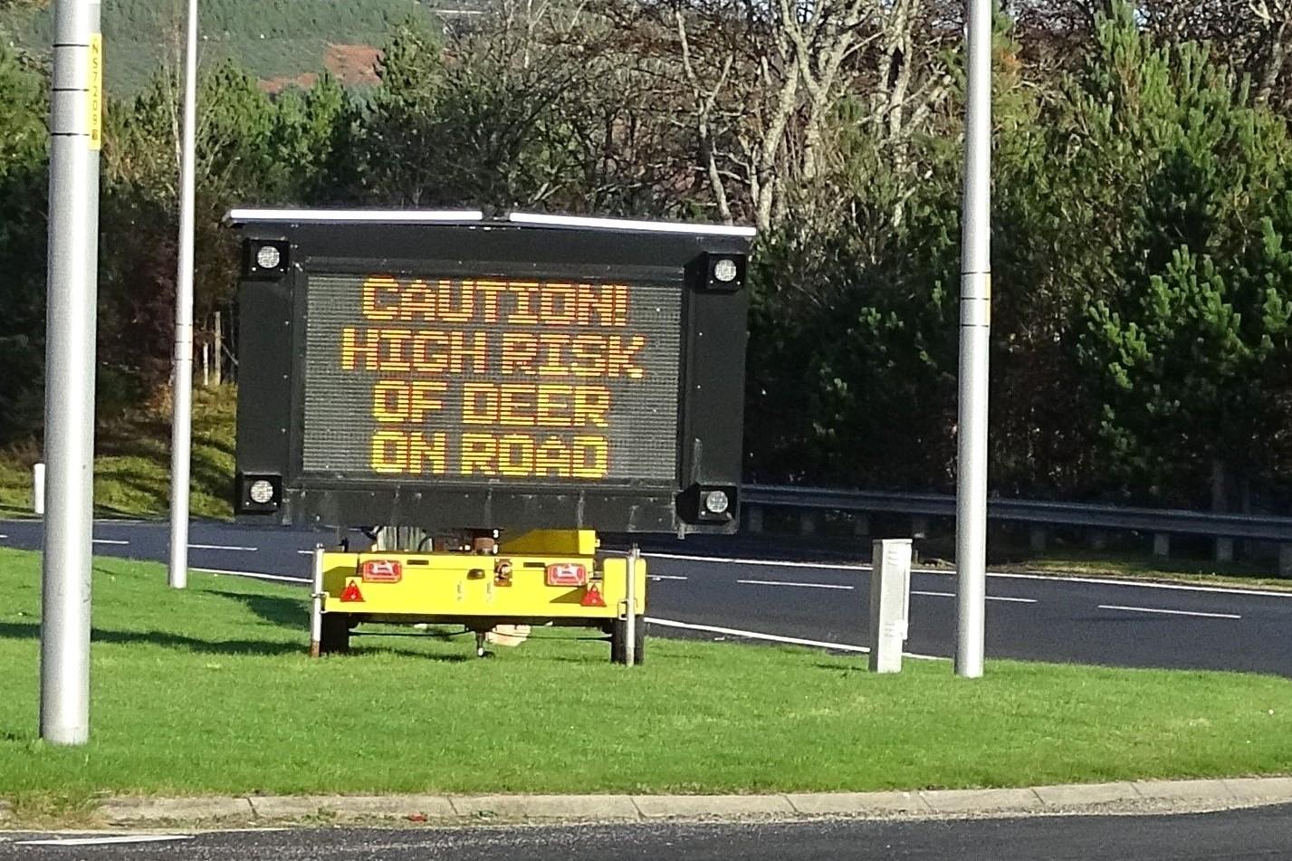 Road sign stating 'caution, high risk of deer on road'.